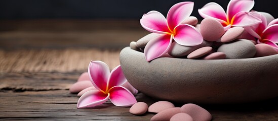 Pink fran flowers and stones in a bowl