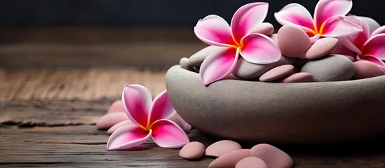 Fotobehang Pink fran flowers and stones in a bowl © Ilgun