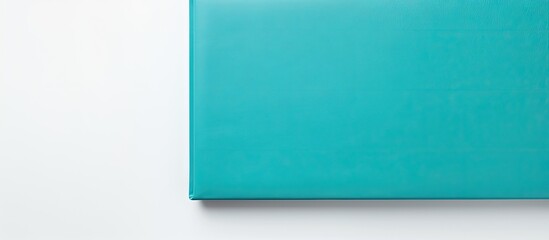 A blue book on a white surface - obrazy, fototapety, plakaty