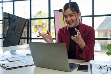 Call center, customer support worker, Asian businesswoman working with laptop talking with customers online. Live, recording data, reviewing business information with online financial customers.