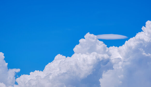 White Cumulus congestus and Pileus clouds on blue sky background in sunny day