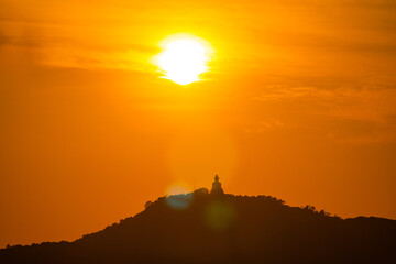 scenery yellow sky glare of sun above Phuket big Buddha.Phuket Big Buddha is one of the island most...