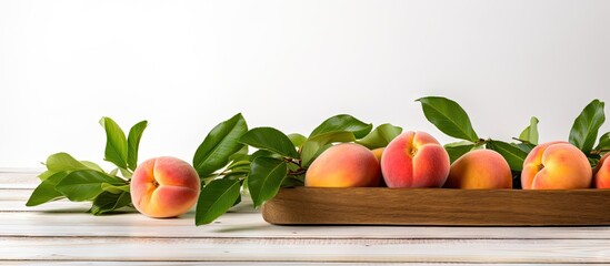 Fresh peaches in a wooden bowl on a white wooden table