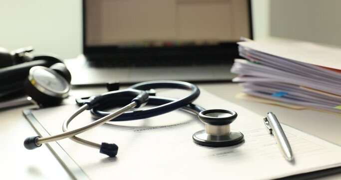 Stethoscope and sheets of paper lie neatly on doctor desk