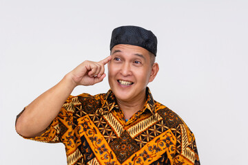 A Indonesian man wearing a batik shirt and a kopiah hat having a spur of the moment idea. Isolated...