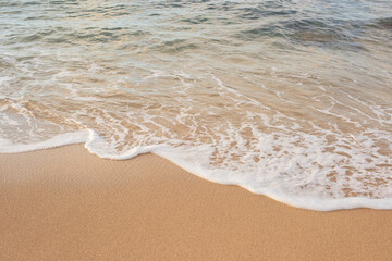 Fototapeta na wymiar Golden sand and ocean water on the shore of a tropical beach 