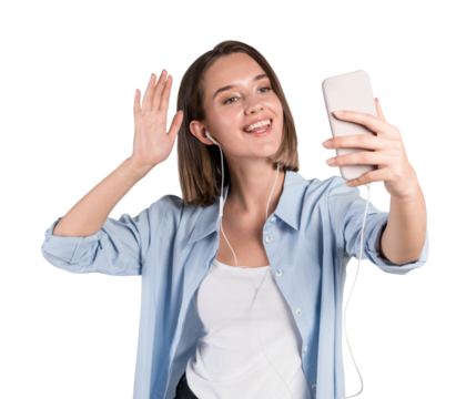 Smiling young woman in casual wear taking a selfie with a phone, wearing earphones, against a white background. Lifestyle and technology concept