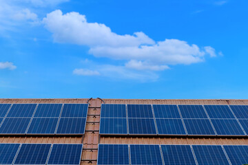 Close-up solar panels mounted on roof on modern building for receive energy from sunlight for converted to electrical energy for use with appliances electricity on blue sky, renewable energy