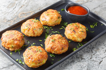 Perkedel Kentang is Potato croquette of ground meat and boiled potatoes with sauce closeup on the plate on the table. Horizontal
