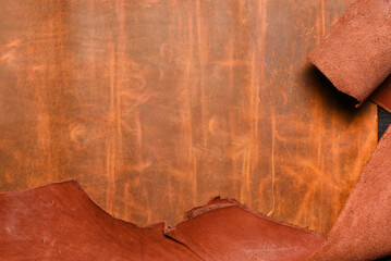 Brown leather rolled up pieces scrolls on the black table background. Top view.
