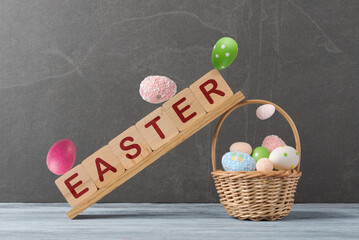 Easter basket with eggs and a wooden block with the word Easter on it - 762054646