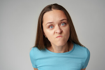 Portrait of angry crazy young woman on gray background - obrazy, fototapety, plakaty