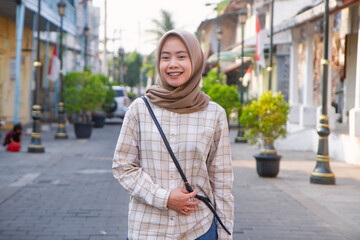 happy asian muslim woman roaming around kota lama or old city area, Semarang, Central Java ,...