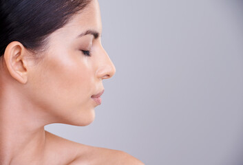 Woman, relax and profile with face in cosmetics, facial treatment or skincare on a gray studio...