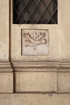 Sculpted Detail Depicting a Cross and Two Crossed Arms at the Sacre Stimmate di San Francesco Church in Rome, Italy
