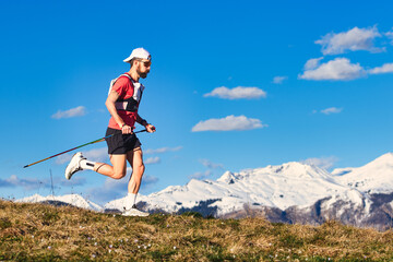 Sporty man practices nordic walking in the hills