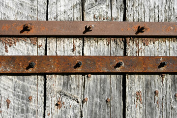 Barres en métal sur un fond de planches en vieux bois gris clair