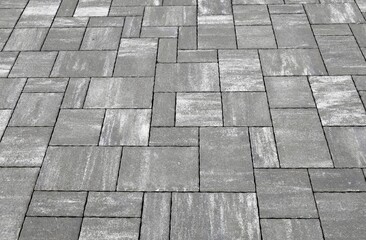 Gray  and white concrete outdoor pavement with tiles of different shapes. Background and texture.