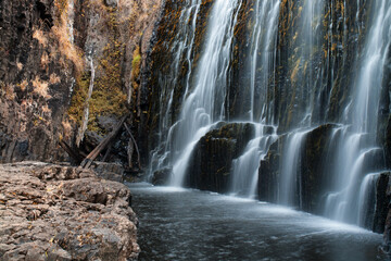 A Tasmanian waterfall detail: Nature's masterpiece, cascading waters amidst lush greenery, creating...