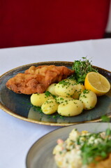 Wiener schnitzel with salad on a restaurant table.