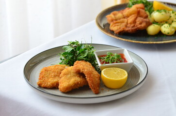Schnitzel with salad in a plate on the table.