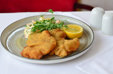 Schnitzel with potatoes and herbs on a plate in a restaurant