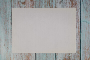 White empty A4 paper sheet on a wooden table. Mockup flatlay with copyspace