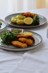 Schnitzel with potatoes and herbs on a plate in a restaurant