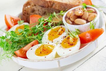 English breakfast. Boiled egg, beans, toast and green herbs.