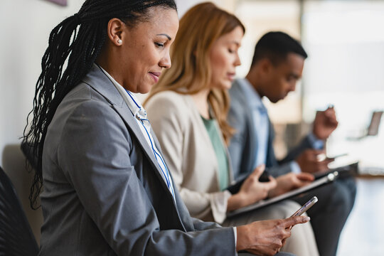 A diverse group of multi-ethnic people waiting for a job interview in front of a corporate office