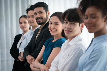 Happy and smiling multiracial office worker hold hand in a line, promoting synergy and collaboration for business success. Diverse professional office worker bond at modern workplace. Concord