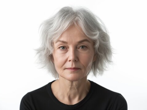 Portrait of a serene mature woman with gray hair looking at the camera against a white background