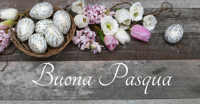 Biglietto d'auguri Buona Pasqua: fiori e uova di Pasqua su fondo in legno con il testo Buona Pasqua.