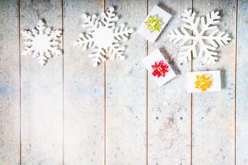 Snowflakes, giftboxes on a wooden background. Christmas winter flatlay with copyspace
