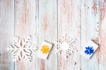 Snowflakes and presents on a light blue wooden background. Christmas winter flatlay with copyspace	