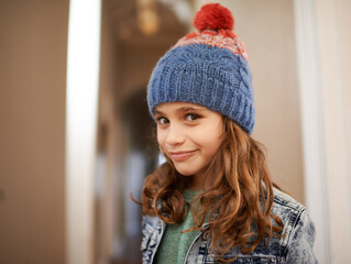 Girl, portrait and child with fashion in winter at home with pride and happiness in clothes with hat. Kid, smile or relax in house with beanie, jacket or casual style on holiday or vacation in Sweden