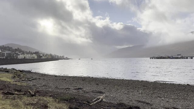 Sun peaking through the fast moving clouds above Loch Eil in Fort William, Scotland