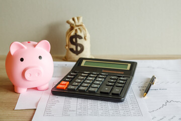A piggy bank and a calculator on the table. Financial concept.