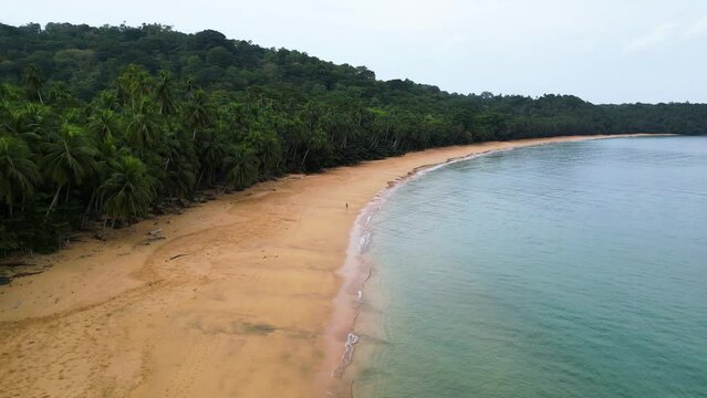 Drone circling a girl walking on the Praia Grande beach on Ilha do Principe, Africa