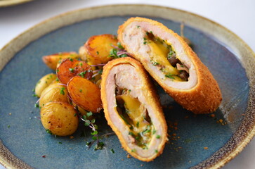 schnitzel stuffed with cheddar cheese, baked potato, baked potato, food served in a restaurant on a...