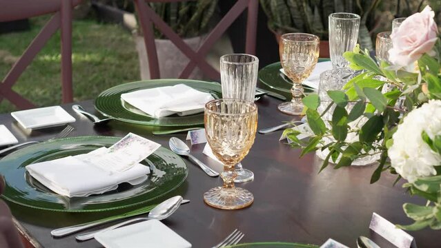 Two crystal glasses placed on the wedding banquet table along with elegant tableware and cutlery