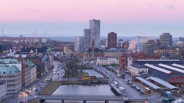 Twilight drone over canals near Malmo Central Station, Oresund Bridge on horizon