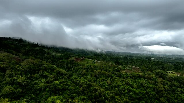 Hyperlapse timelapse of clouds moving over mountains of Bali during rainy day, Indonesia. Aerial forward