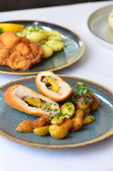 schnitzel stuffed with cheddar cheese, baked potato, baked potato, food served in a restaurant on a plate, Czech food
