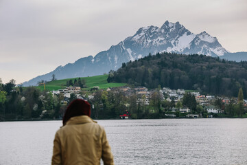 A woman is enjoying beautiful view of mountains on lake lucerne, Switzerland.