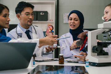 Obraz premium Medical, meeting and laptop for team in office in discussion, brainstorming and planning. Doctor, nurse and computer on desk, teamwork or workshop for Model Internal organ.