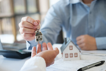 The real estate agent hands the keys to the customer. Real estate investment loans