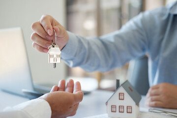 The real estate agent hands the keys to the customer. Real estate investment loans