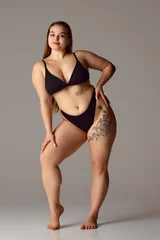 Poster Full length portrait of young chubby woman posing in lingerie against grey studio background. Self-expression. Concept of natural beauty, femininity, body positivity, dieting, fitness, lose-weight. © Lustre