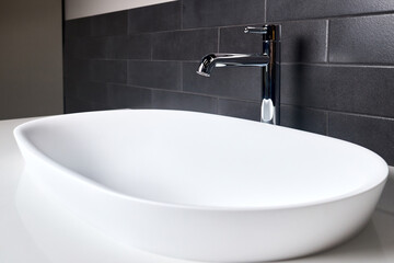 Fototapeta premium Interior of bathroom with washbasin and faucet. Bathroom interior sink with white stoneware countertop modern flat minimalistic design.